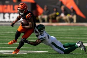 The cover for this NFL player props week 11 article shows Brandon Stephens #21 of the New York Jets tackling Ja'Marr Chase #1 of the Cincinnati Bengals.
