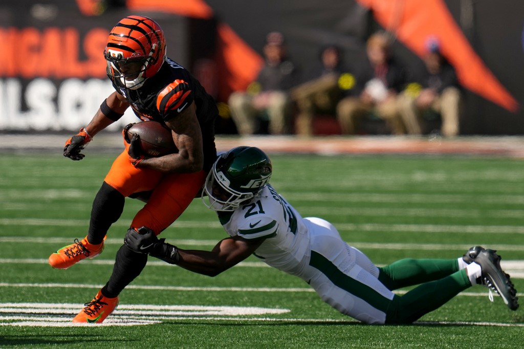 The cover for this NFL player props week 11 article shows Brandon Stephens #21 of the New York Jets tackling Ja'Marr Chase #1 of the Cincinnati Bengals.