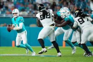 The cover for this NFL player props Week 16 article shows Quinn Ewers #14 of the Miami Dolphins looking to throw a pass against the Jacksonville Jaguars.