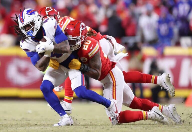 James Cook #4 of the Buffalo Bills runs the ball and is tackled by Justin Reid #20 of the Kansas City Chiefs.