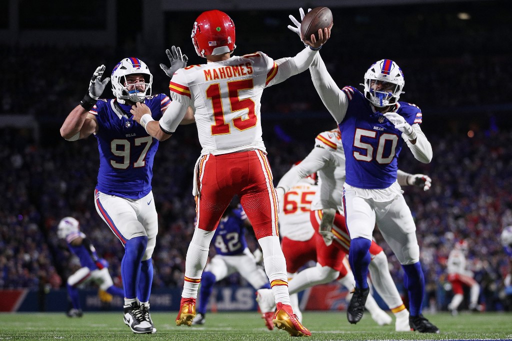 The cover for this NFL picks week 11 article shows Patrick Mahomes #15 of the Kansas City Chiefs throwing as Joey Bosa #97 and Greg Rousseau #50 of the Buffalo Bills defend.