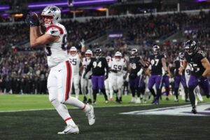 The cover for this NFL Picks Week 17 article shows Hunter Henry #85 of the New England Patriots catching a touchdown pass against the Baltimore Ravens.