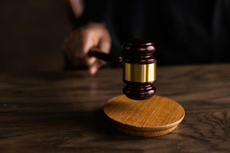 A judge’s gavel strikes a sound block on a courtroom bench