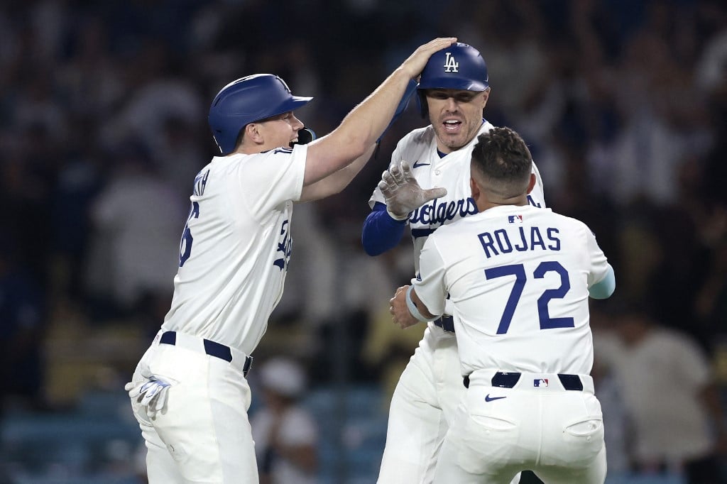 Freddie Freeman, Will Smith and Miguel Rojas the Los Angeles Dodgers celebrate after defeating the Chicago White Sox.