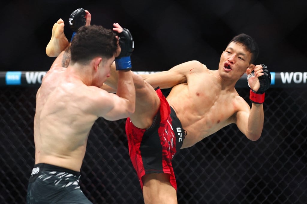 Sumudaerji of China kicks Mitch Raposo in a flyweight bout during UFC 314.