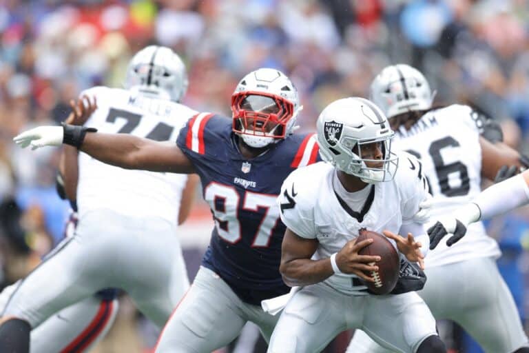 Geno Smith #7 of the Las Vegas Raiders looks to pass while under pressure from Milton Williams #97 of the New England Patriots