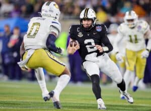 Diego Pavia #2 of the Vanderbilt Commodores runs the ball at Trenilyas Tatum #0 of the Georgia Tech Yellow Jackets