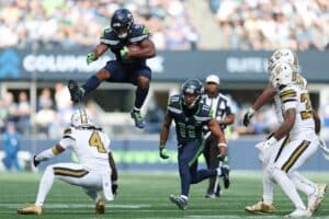 Kenneth Walker III #9 of the Seattle Seahawks leaps over Kool-Aid McKinstry #4 of the New Orleans Saints