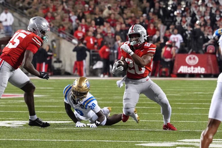 UCLA v Ohio State - Oddstrader - Oddstrader The cover for this college football conference winner predictions article shows running back James Peoples #20 of the Ohio State Buckeyes carrying the ball after braking the tackle of Defensive back Scooter Jackson #28 of the UCLA Bruins.