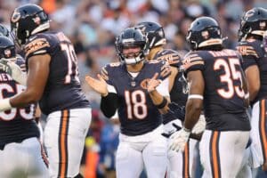 Caleb Williams #18 of the Chicago Bears huddles with teammates against the Buffalo Bills.