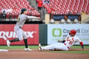 Lars Nootbaar #21 of the St. Louis Cardinals is forced out at second base as Zack Gelof #20 of the Athletics turns a double play in the first inning.