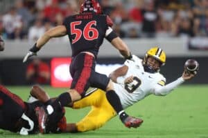Jaron-Keawe Sagapolutele #3 of the California Golden Bears tries to get a pass off under pressure from the San Diego State Aztecs