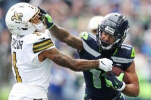 Jaxon Smith-Njigba #11 of the Seattle Seahawks carries the ball defended by Alontae Taylor #1 of the New Orleans Saints