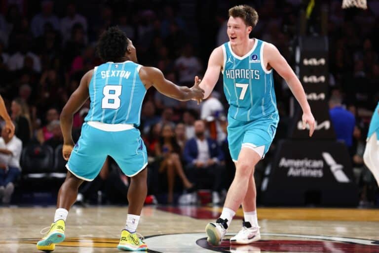 Collin Sexton #8 and Kon Knueppel #7 of the Charlotte Hornets celebrate against the Miami Heat.