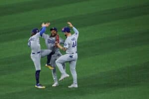 Enrique Hernández #8, Justin Dean #75, and Andy Pages #44 of the Los Angeles Dodgers celebrate after defeating the Toronto Blue Jays.