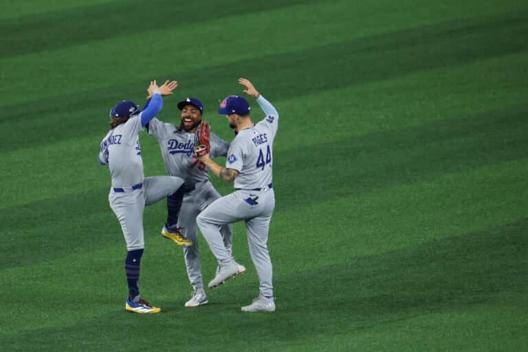 Enrique Hernández #8, Justin Dean #75, and Andy Pages #44 of the Los Angeles Dodgers celebrate after defeating the Toronto Blue Jays.