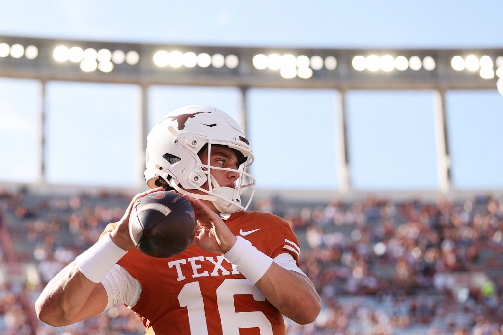 The cover for this Friday night college football article shows Arch Manning #16 of the Texas Longhorns warming up prior to a game against the Arkansas Razorbacks