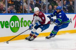 The cover for this NHL parlays today article shows Cale Makar #8 of the Colorado Avalanche skating the puck ahead of Evander Kane #91 of the Vancouver Canucks