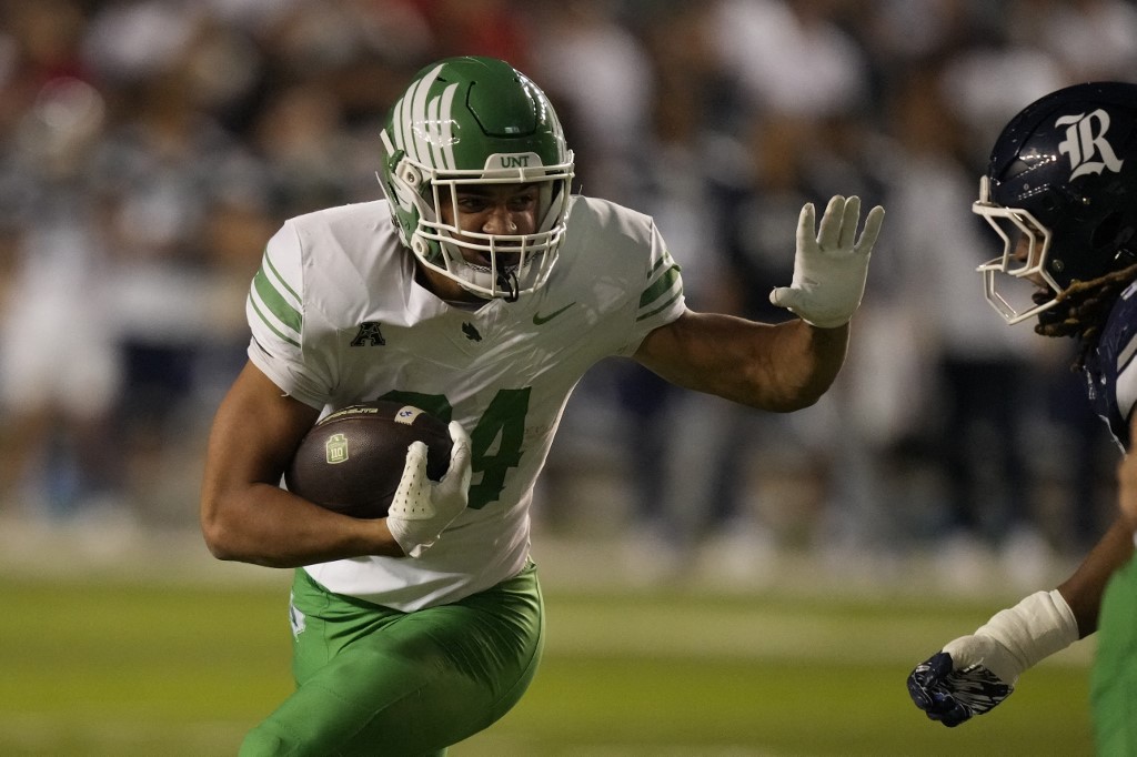 The cover for this Friday night college football article shows Caleb Hawkins #24 of the North Texas Mean Green carrying the ball against the Rice Owls.