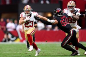 San Francisco 49ers v Arizona Cardinals - NFL 2025 - Oddstrader The cover for this Monday night football picks article shows Christian McCaffrey #23 of the San Francisco 49ers carrying the ball against the Arizona Cardinals.