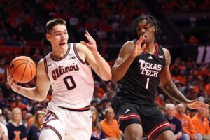 Texas Tech v Illinois - Oddstrader The cover for this college basketball picks today article shows David Mirkovic #0 of the Illinois Fighting Illini driving to the basket against Tyeree Bryan #1 of the Texas Tech Red Raiders