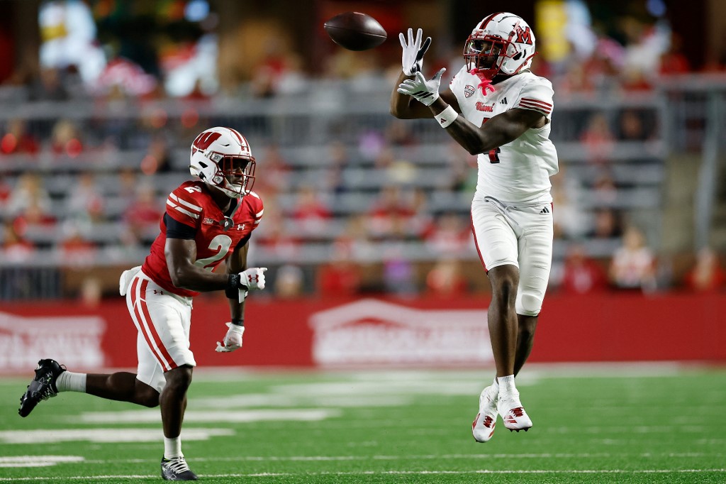Deion Colzie #4 of the Miami (OH) Redhawks catches a pass in front of Ricardo Hallman #2 of the Wisconsin Badgers .