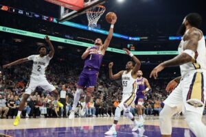 The cover for this NBA picks today article shows Devin Booker #1 of the Phoenix Suns laying up a shot past Kevon Looney #55 of the New Orleans Pelicans.