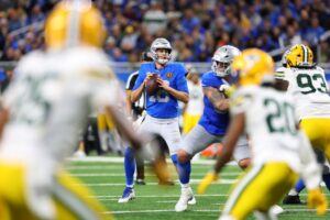 The cover for this Thursday night football picks article shows Jared Goff #16 of the Detroit Lions plays against the Green Bay Packers.