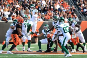 The cover for this Thursday night football picks article shows Justin Fields #7 of the New York Jets passing the ball against the Cincinnati Bengals.