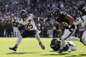 The cover for this Sunday morning football picks article shows Kyle Monangai #25 of the Chicago Bears running the ball against Teddye Buchanan #40 of the Baltimore Ravens.