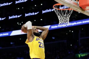 The cover for this NBA player props today article shows LeBron James #23 of the Los Angeles Lakers dunks the ball against the Minnesota Timberwolves.