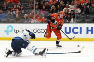 Winnipeg Jets v Anaheim Ducks - Oddstrader The cover for this NHL picks today article shows Mason McTavish #23 of the Anaheim Ducks shooting the puck against Neal Pionk #4 of the Winnipeg Jets