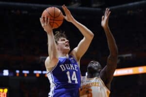 The cover for the college basketball picks today shows Nikolas Khamenia #14 of the Duke Blue Devils drives in for a layup against DeWayne Brown II #6 of the Tennessee Volunteers