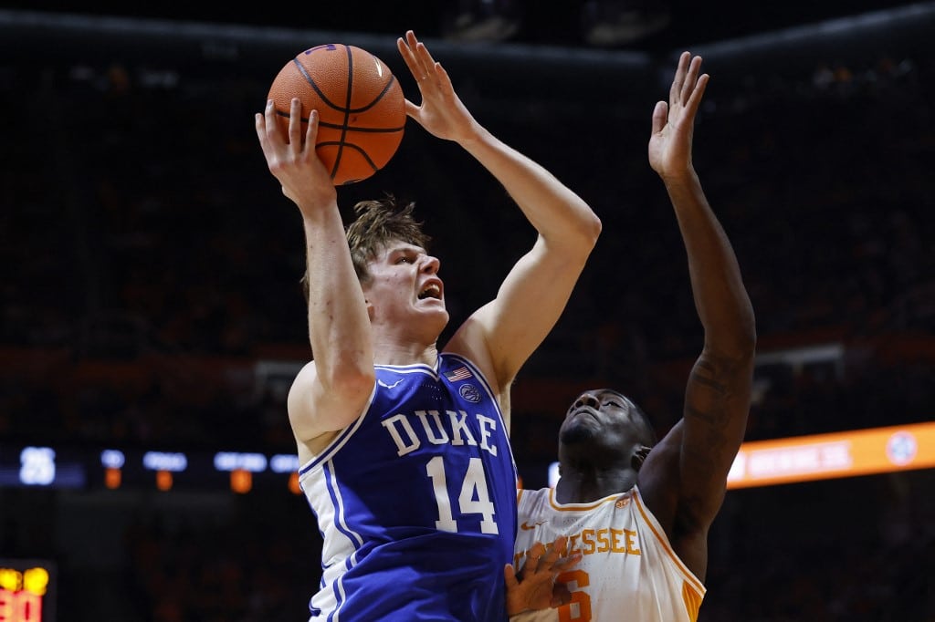 The cover for the college basketball picks today shows Nikolas Khamenia #14 of the Duke Blue Devils drives in for a layup against DeWayne Brown II #6 of the Tennessee Volunteers