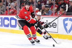 The cover for this NHL picks today article shows Sam Rinzel #6 of the Chicago Blackhawks controls the puck against Tim Stützle #18 of the Ottawa Senators