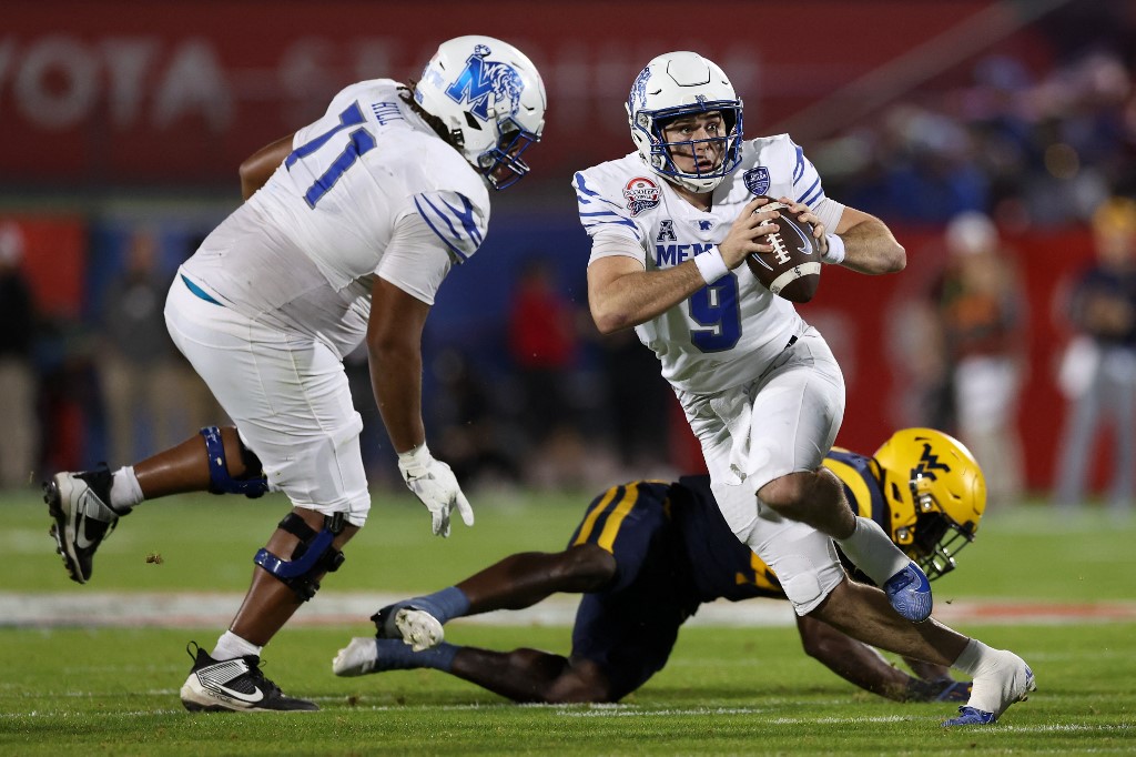 The cover for this Thursday night college football article shows Seth Henigan #9 of the Memphis Tigers running with the ball against the West Virginia Mountaineers