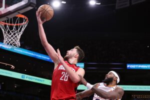 Houston Rockets' Alperen Sengun, one of our top NBA player props today, attempts a layup against Royce O'Neale #00 of the Phoenix Suns.