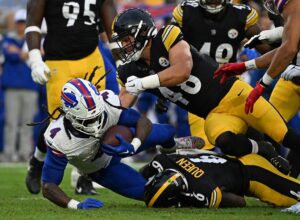 James Cook #4 of the Buffalo Bills is tackled by Patrick Queen #6 of the Pittsburgh Steelers.