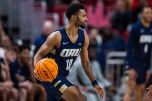 Isaac McBride of the Oral Roberts Golden Eagles , one of our top College basketball picks today, handles the ball against the Texas Tech Red Raiders.
