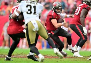 New Orleans Saints v Tampa Bay Buccaneers - NFL 2025 - Oddstrader The cover for this Thursday night football picks article shows Baker Mayfield #6 of the Tampa Bay Buccaneers scrambling with the ball against the New Orleans Saints.