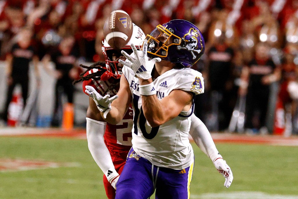 Brock Spalding #10 of the East Carolina Pirates makes a catch against Jamel Johnson #21 of the NC State Wolfpack