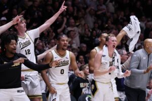 Iowa State v Purdue - Oddstrader The cover for this college basketball picks today article shows Daniel Jacobsen #12, C.J. Cox #0 and Fletcher Loyer #2 of the Purdue Boilermakers celebrating against the Iowa State Cyclones.