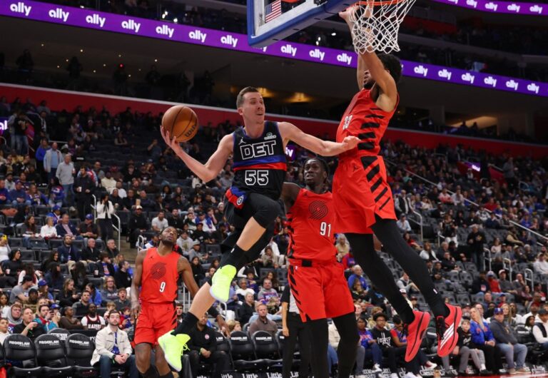 The cover for this NBA player props today article shows Duncan Robinson #55 of the Detroit Pistons looking to pass around Toumani Camara #33 of the Portland Trail Blazers.