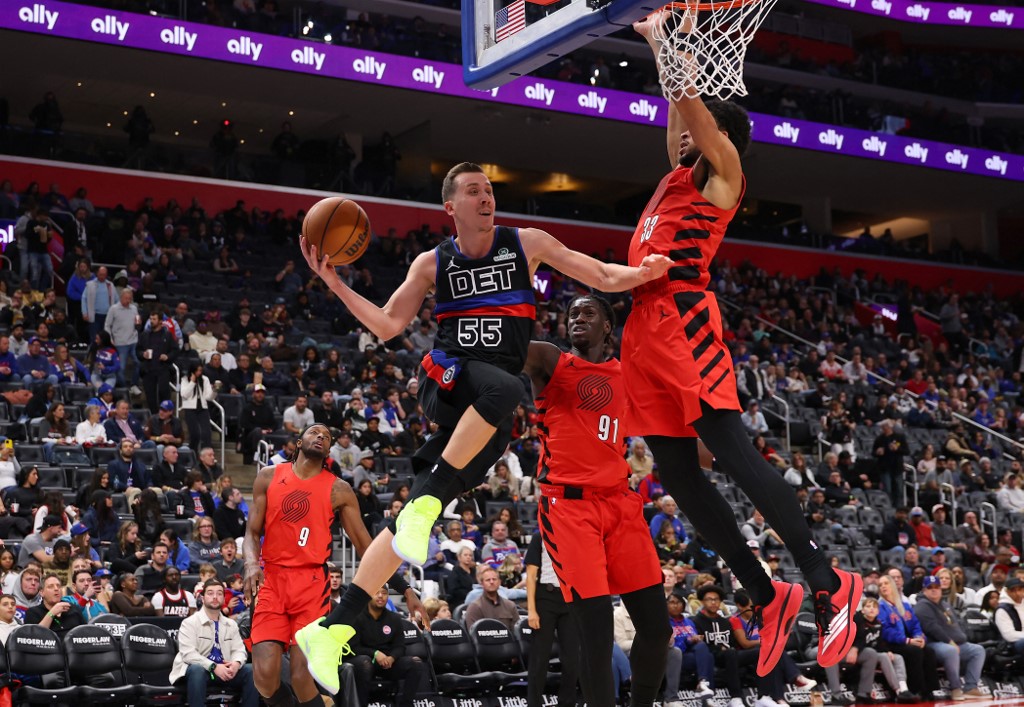 The cover for this NBA player props today article shows Duncan Robinson #55 of the Detroit Pistons looking to pass around Toumani Camara #33 of the Portland Trail Blazers.