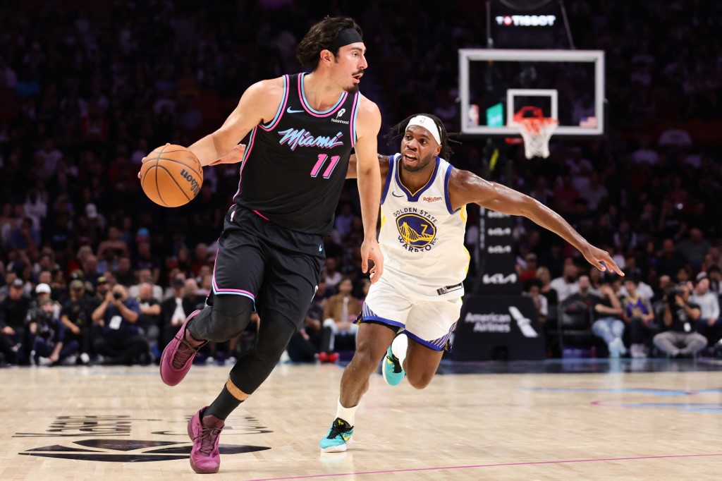 The cover for this NBA player props today article shows Jaime Jaquez Jr. #11 of the Miami Heat driving past Buddy Hield #7 of the Golden State Warriors.