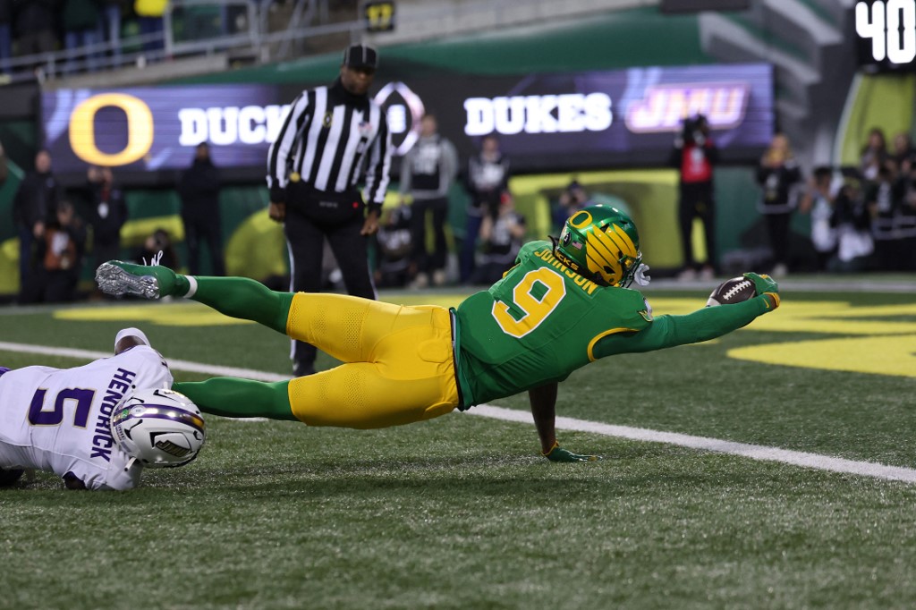 The cover for this college football player props today article shows Jamari Johnson #9 of the Oregon Ducks scoring for a touchdown during the first quarter against the James Madison Dukes.