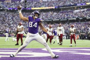 Washington Commanders v Minnesota Vikings - NFL 2025 - Oddstrader The cover for this NFL sunday night football bets article shows Josh Oliver #84 of the Minnesota Vikings scoring a third quarter touchdown against the Washington Commanders