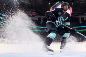 The cover for this NHL picks today article shows Matty Beniers #10 of the Seattle Kraken stopping against the Colorado Avalanche.