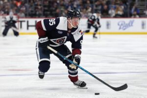 The cover for this NHL parlay picks today article shows Victor Olofsson #95 of the Colorado Avalanche advancing the puck against the Winnipeg Jets.