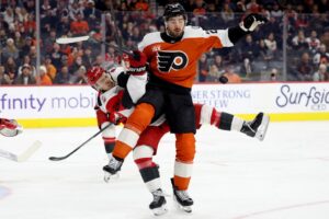 Carolina Hurricanes v Philadelphia Flyers - Oddstrader Noah Cates #27 of the Philadelphia Flyers and Logan Stankoven #22 of the Carolina Hurricanes reach for a stray puck during the second period.